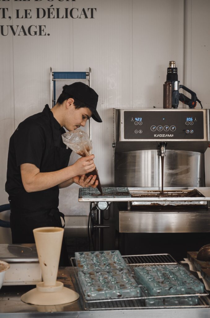 Un artisan chocolatier dans l'atelier de fabrication de la chocolaterie Fèves à Notre-Dame d'Oé