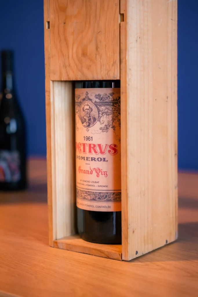 Une bouteille de Petrus 1961 dans un coffret en bois.