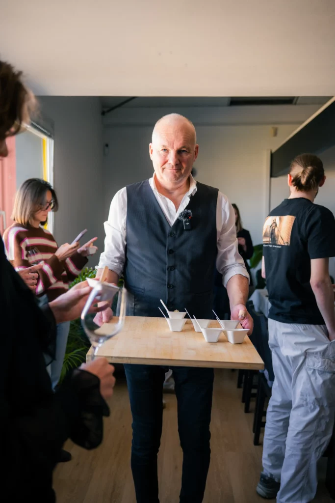 Christophe Boisselier tient un plateau avec des mignardises qu’il distribue pour la dégustation.
