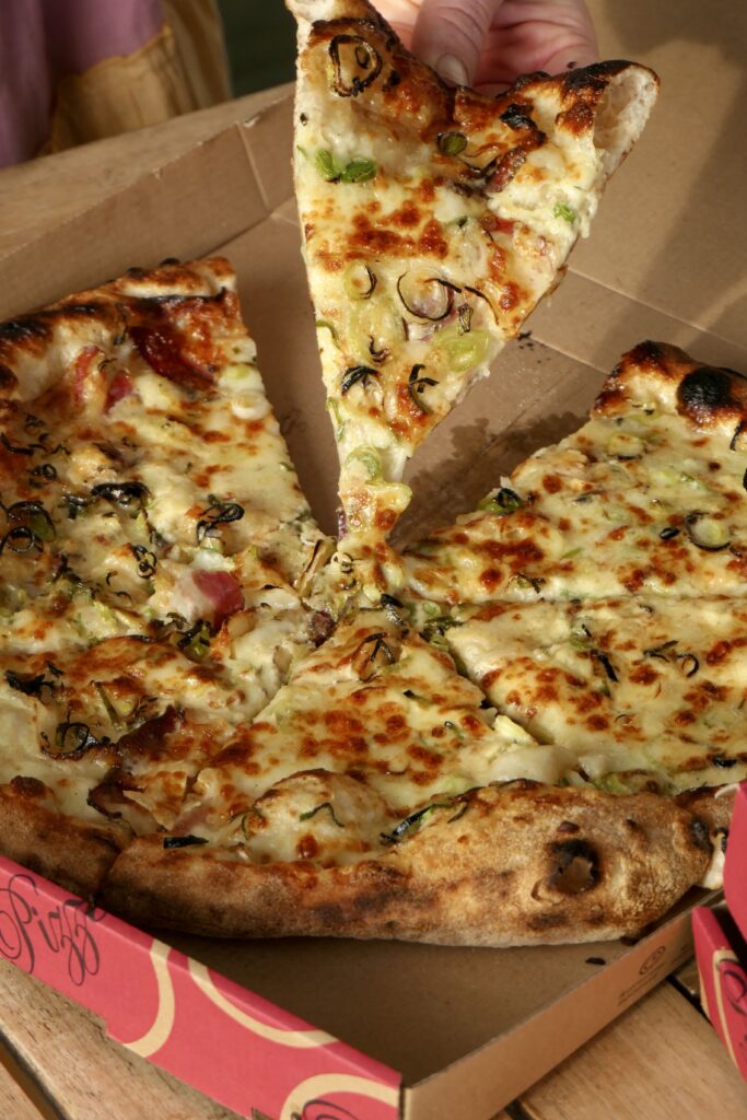 Découpe de le pizza du moment à emporter chez Pizza Pap's au Teich, adresse de street food italienne authentique et faite maison.