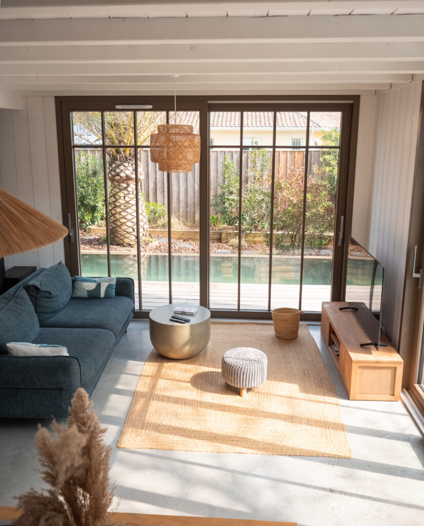 Salon et extérieurs de la Villa du Lac, proposée par Les Cocons du Bassin. Une villa en bois familiale à proximité du lac de Cazaux.