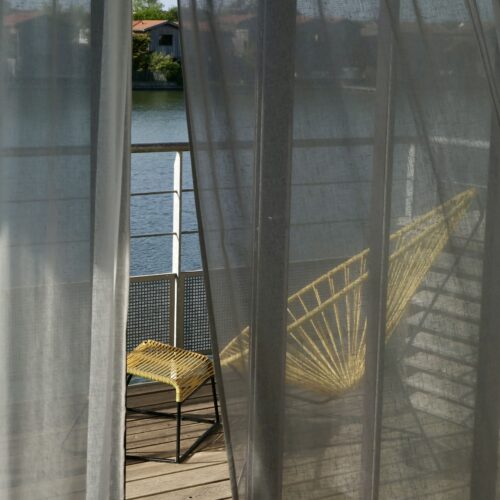 Une des terrasses, avec vue sur l'eau, dans les suites disponibles à la résidence hôtelière Les 12 de Larros au port de Larros, à Gujan-Mestras.