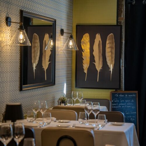 La salle chaleureuse, avec les tables dressées pour le service du soir, au restaurant bistronomique Le Bistrot de Léon, dans le centre ville de Limoges