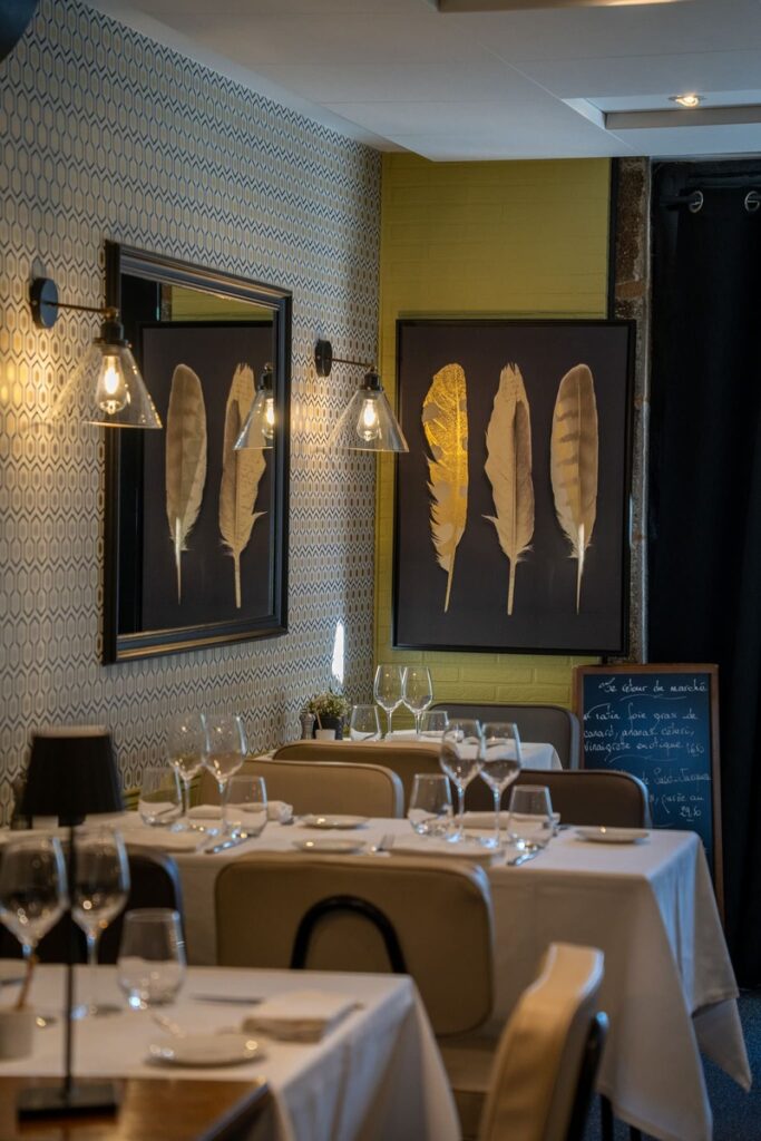 La salle chaleureuse, avec les tables dressées pour le service du soir, au restaurant bistronomique Le Bistrot de Léon, dans le centre ville de Limoges
