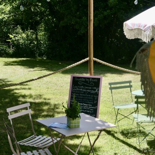 Jardin caché et romantique avec tables, parasols et cousins au café Maison Esmé à Audenge