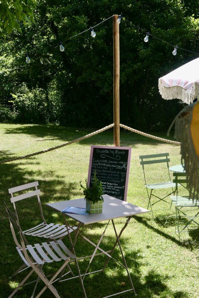 Jardin caché et romantique avec tables, parasols et cousins au café Maison Esmé à Audenge