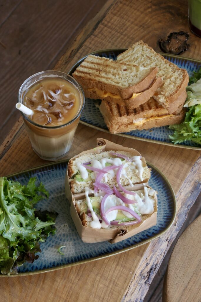 Sandwichs breaky et cheesy à base de pain num Pang, avec un iced latte, chez Nea's Corner, brunch et coffee shop à Claouey