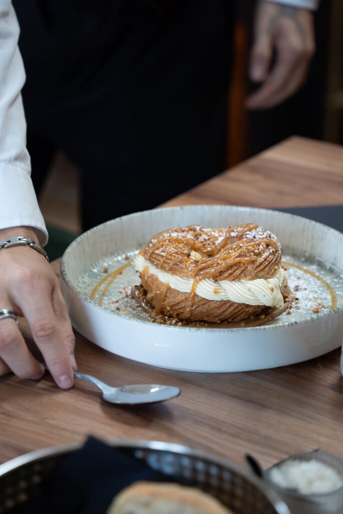 Dessert Paris Brest dans une assiette servie par le serveur